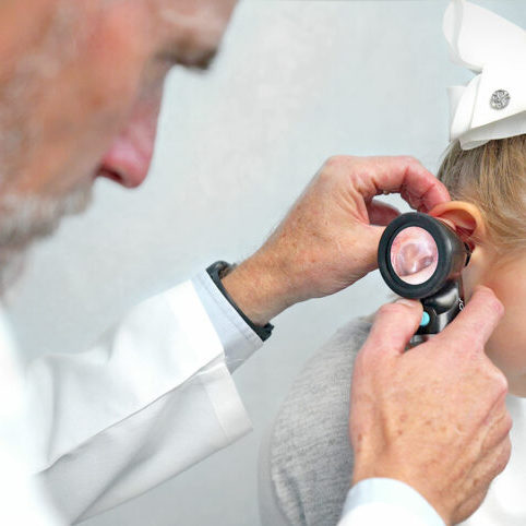 physician using Wispr Digital Otoscope to perform ear exam (otoscopy) with pediatric patient.